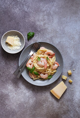 Spaghetti with shrimps, with sauce and parmesan on a concrete background. Top view. Menu. Shrimp pasta.