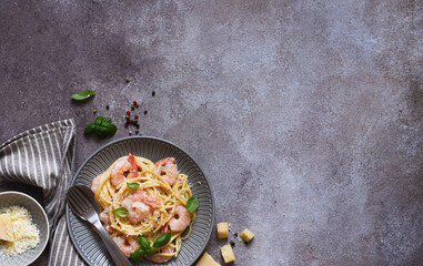 Spaghetti with shrimps, with sauce and parmesan on a concrete background. Top view. Menu. Shrimp pasta.