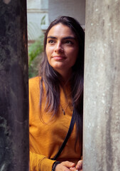 Narrow angle portrait of woman between pillars of dark and light.