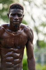 Working out in the morning. Young strong african man in sportswear exercising outdoors. Sport, training concept. Healthy active lifestyle. TRX