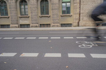 Bicycle lane with white symbol marking on an asphalt city street with blurred cyclist