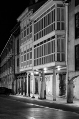 Lonely street of old buildings with wooden balconies in the evening in black and white
