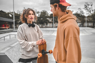 Guy listening to talking girl with skateboard