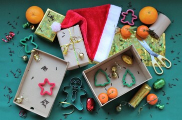 Christmas composition: wrapping gifts. Gift boxes, paper, ribbon, scissors, pasta cutters with Christmas motifs in red, green and gold