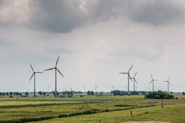 Fototapeta na wymiar Wind wheels for renewble energy on the flat marshland of North Germany