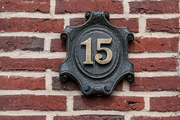 House number made of metal on a brick wall