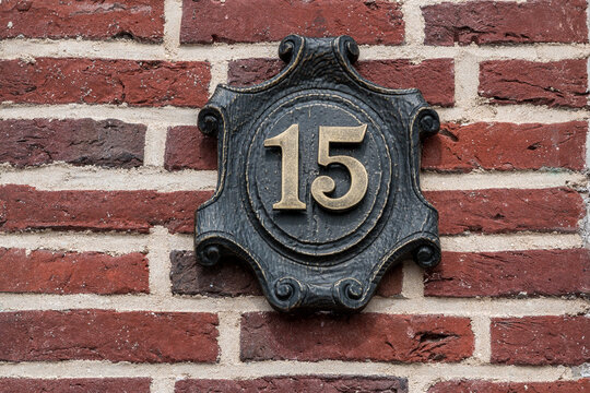 House number made of metal on a brick wall