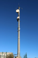 Communication tower on a blue sky background, selective focus