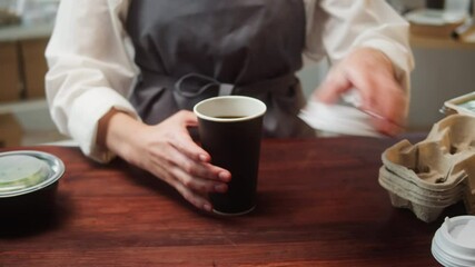 Food delivery service. Woman closing hot drink in paper cup close-up. Preparing take away meals. Healthy eating habits. Online contactless food shopping.