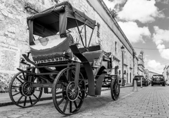 Fototapeta na wymiar Dramatic black and white image of a old historical motorized carriage for giving tourist rides in the colonial district of Santo Domingo, Dominican Republic.