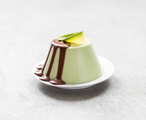 Avocado creamy pudding,  Panna Cotta witch chocolate topping on a plate on a light gray background