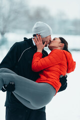 Young couple going for a run together during a snow on a cold winter day