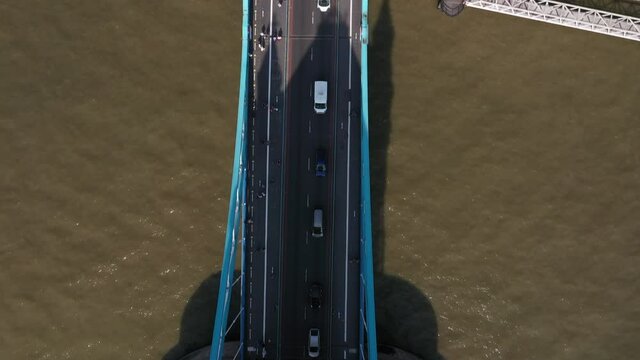 Top down panning footage of slowly moving cars on busy road on Tower Bridge. Historic landmark over Thames river. London, UK