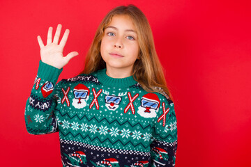 little kid girl wearing knitted sweater christmas over red background showing and pointing up with fingers number five while smiling confident and happy.