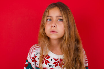 little kid girl wearing knitted sweater christmas over red background Pointing down with fingers...