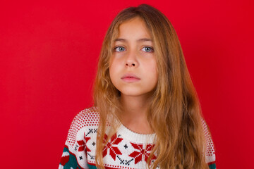 little kid girl wearing knitted sweater christmas over red background Pointing down with fingers showing advertisement, surprised face and open mouth