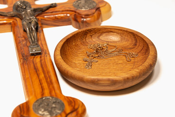 Orthodox wooden cross and a gold chain with a cross in a wooden saucer. Consecration of the cross and chain in the temple.