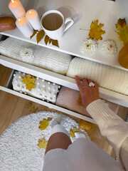 Modern open chest of drawers with woman clothes and accessories in bedroom
