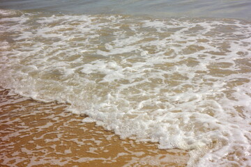 olas rompientes y espuma marina en la orilla del mar