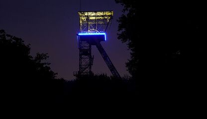 Old illuminated coal mine tower in germany - obrazy, fototapety, plakaty