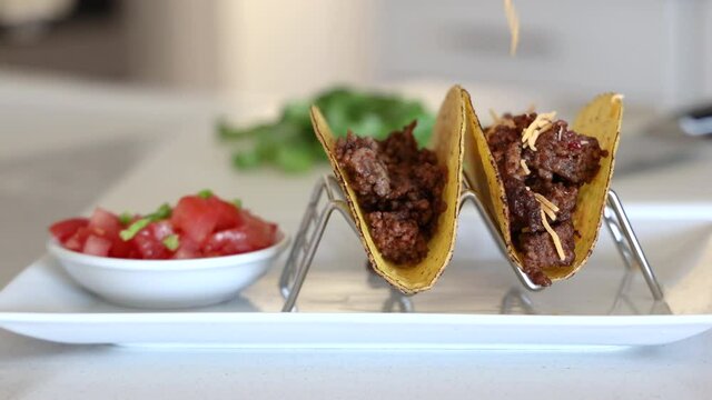Adding Shredded Cheese to Crunchy Beef Tacos