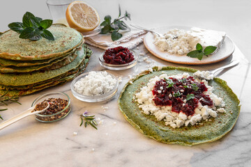 Close-up of pink pancakes with beetroot and feta, and green pancakes with spinach