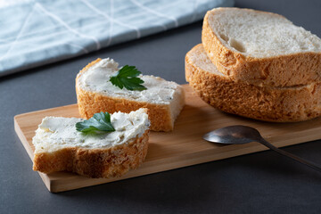 White bread on the plate with curd cheese and herbs. Decorated with green herbs. Health food
