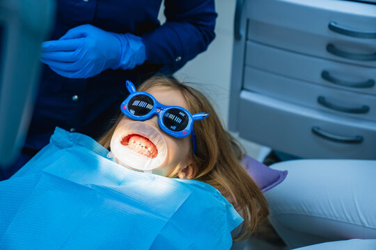 kid girl with oral dilator at dentist's appointment. treatment of teeth