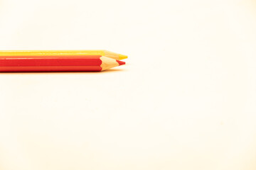 Red and yellow coloring pencils on a white background