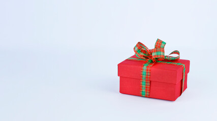 Red gift box with plaid bow on white background banner. Stock photo