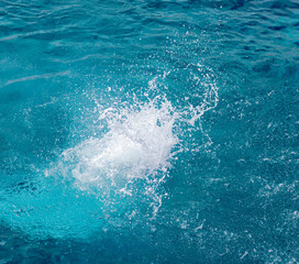 Obraz premium Splashes of blue, sea water with foam bubbles. A splash of nature on a summer day. blue sea background with splashing water. sea vacation concept.