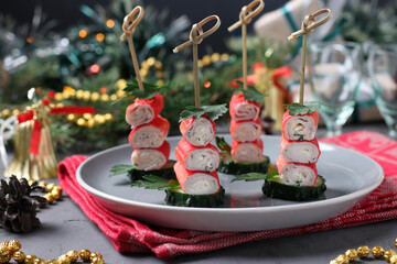 Canapes with crab sticks, cheese, garlic and cucumber on gray background. Festive snack © Anzhela