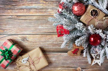 A christmas wreath with a wrapped gifts and other beautiful New Year's decoration is on a wooden background. Free space for text. View from the top point.