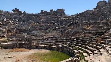 Fototapeta na wymiar Ruins of an ancient amphitheater. Roman amphitheater in Turkey.Ancient stones of the excavated historic city. Turkey, Fetiya, August 13, 2021