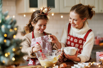 Cute little daughter girl helping mother to make dough for Christmas cookies in cozy kitchen at home