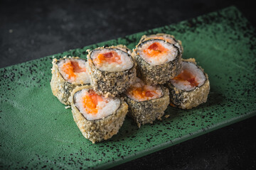 hot sushi roll on a black plate