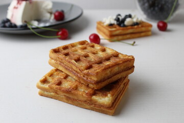 breakfast delicious snack two soft Belgian waffles lie on top of each other next to blueberries cherry cheese cottage cheese with space for text and with copyspace