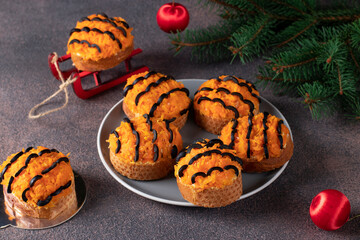 Tiger canapes for New Year 2022 of salted herring, carrot and black olives on croutons of white bread on brown background. Close-up