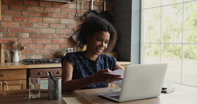 Attractive African woman open envelope with letter notification inside read information smile feels satisfied. Concept of invitation, good news, entrepreneur check paper correspondence routine concept