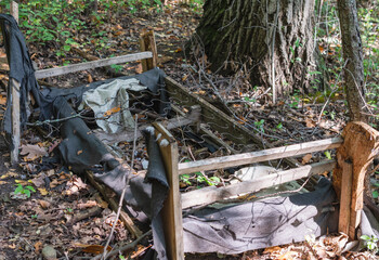 Bed left in the woods to decay.  Example of illegal dumping.