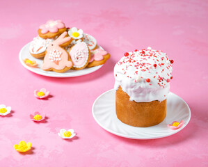 Easter bread or Traditional Easter Cake on Icing and confectionery sprinkles as modern Decoration on pink background with copy space