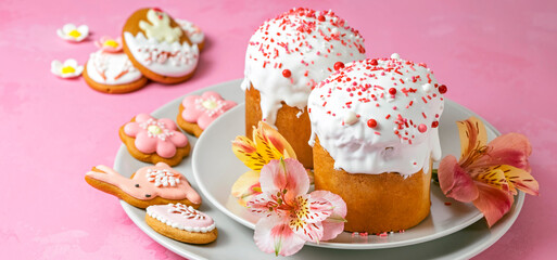 Easter bread or Traditional Easter Cake on Icing and confectionery sprinkles as modern Decoration on pink background with copy space