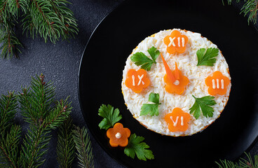 New Year's festive salad in the shape of clock on black plate on gray background