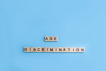 Words Age Discrimination. Wooden blocks with letters on blue background. Age equality concept. Copy...