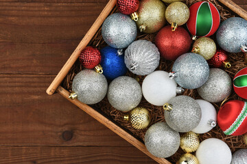 Christmas Flat Lay - Wood Box of Christmas Tree Ornaments on a rustic dark wood surface.