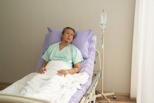 Asian senior or elderly old male patient lie down handle the bed with hope on a bed in the hospital. 