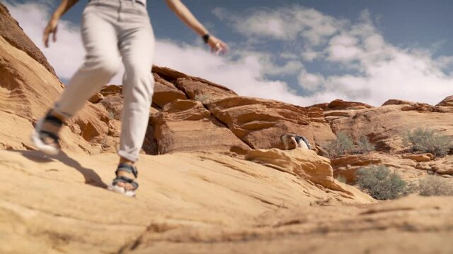 Young female adult hiker on a trail among the sandstone cliffs in Utah, USA. Cosmic landscape, adventure and travel concept.