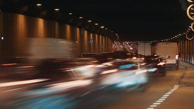 Time lapse traffic jam underground passage road, tunnel underpass roadway in modern big city in evening. Timelapse of busy highway. Cars rush hour drive way, car lights trail fast motion zoom out shot