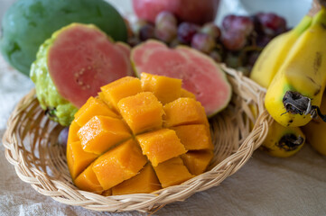 Naklejka na ściany i meble Exotic fruits of Cyprus, fresh yellow juicy mango, ripe pink guava, bananas and sweet table grapes