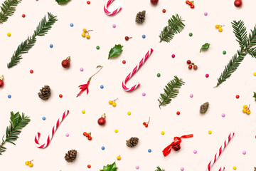 Christmas pattern made of candy canes, pine cone, pine branches, red, yellow berries and colorful...